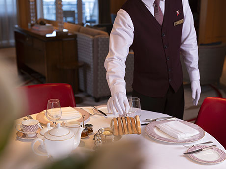 Butler deckt Frühstückstisch in Queens Grill Suite