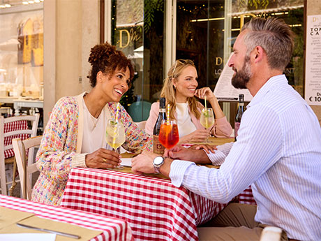 Drei Personen am Tisch eines Straßenrestaurants